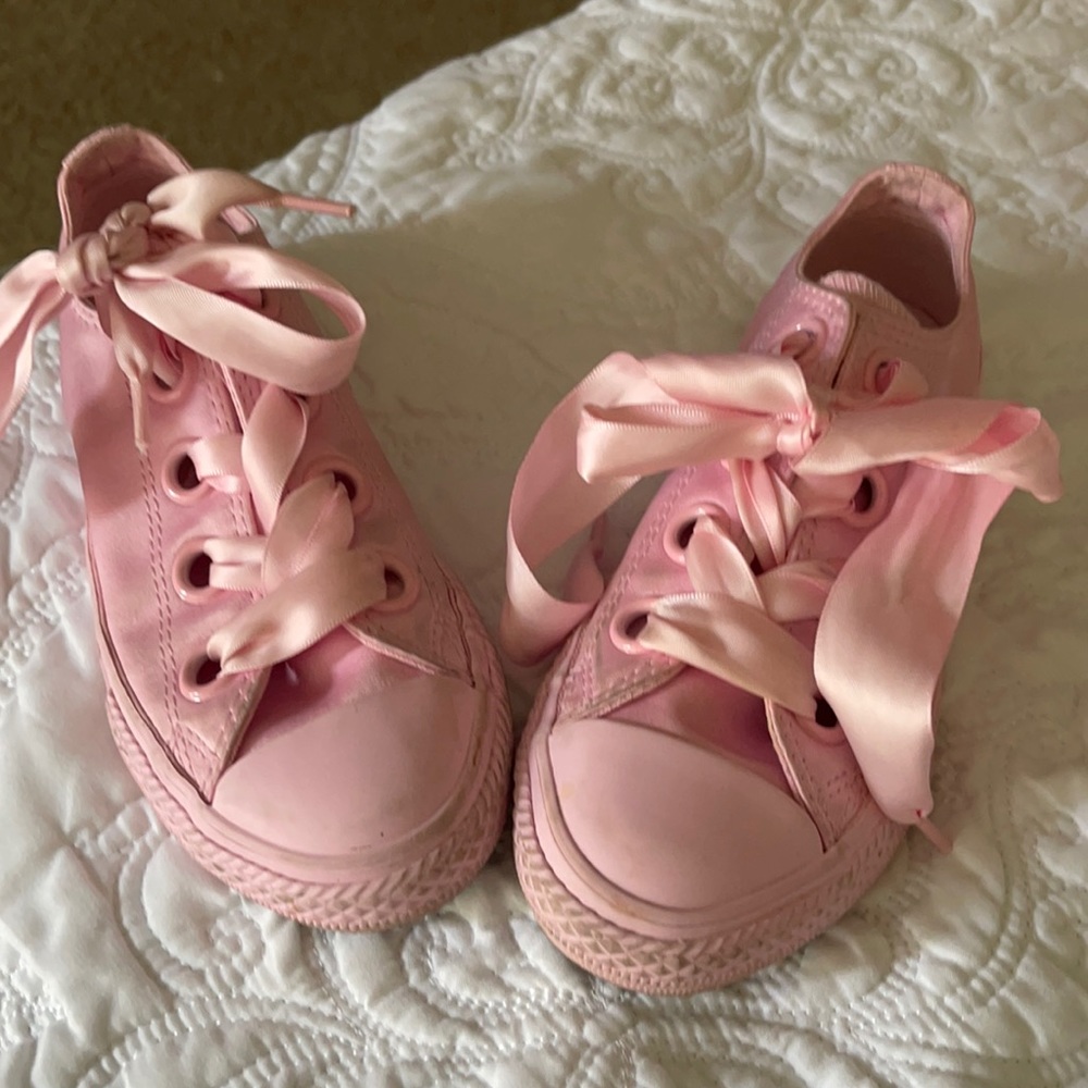 Cute pink converse with a silky wide shoe strings.